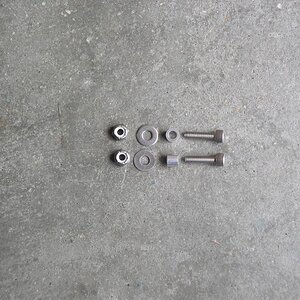 Bolts, sleeves, washers and nuts laid out.