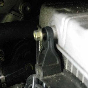 Loosen top left fan mounting bolt