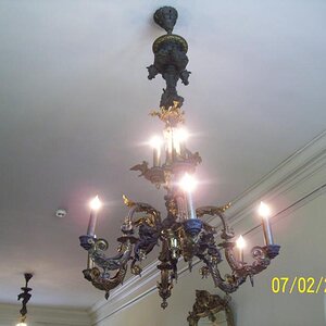 Chandelier with horse heads and what not. Used to be gas then was converted. 2 in that ceiling and they each weigh 2000 pounds. Explaination about the