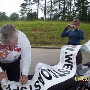 John signing the banner and Sherry taking his picture.