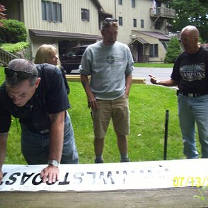 Mike signing the banner, Kim behind, then Lou and Dudley.