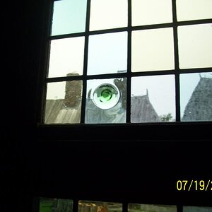 Blown glass from France in the windows. The bubble is the end of the blow. The makers used to leave the nipple on when finished. This would stick out 