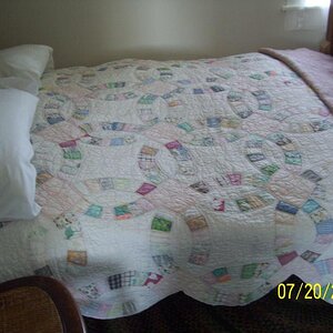 Wedding ring quilt on this old bed. Most had feather ticking pillows and mattresses. Also underlying mattress of straw. Some of the beds had the rope 