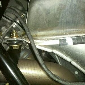 Close up of where the wiring harness is unprotected against the sharp metal edge of the fuel tank.