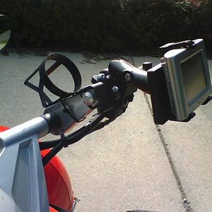 FunkyCupHolder!  Purchased from Pilot Truck Stop.  Cost $1.19 and used two wire ties to secure.  4" bar risers from ESI.  Oh, on the Ram mount the GPS