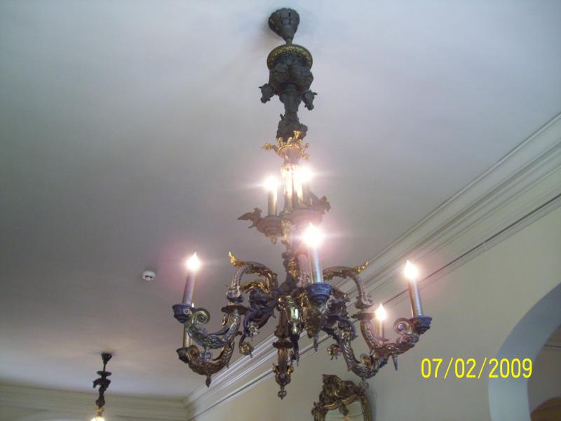 Chandelier with horse heads and what not. Used to be gas then was converted. 2 in that ceiling and they each weigh 2000 pounds. Explaination about the