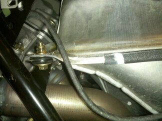 Close up of where the wiring harness is unprotected against the sharp metal edge of the fuel tank.