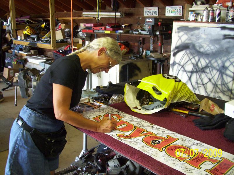 Jennifer signing Spyderlover banner.