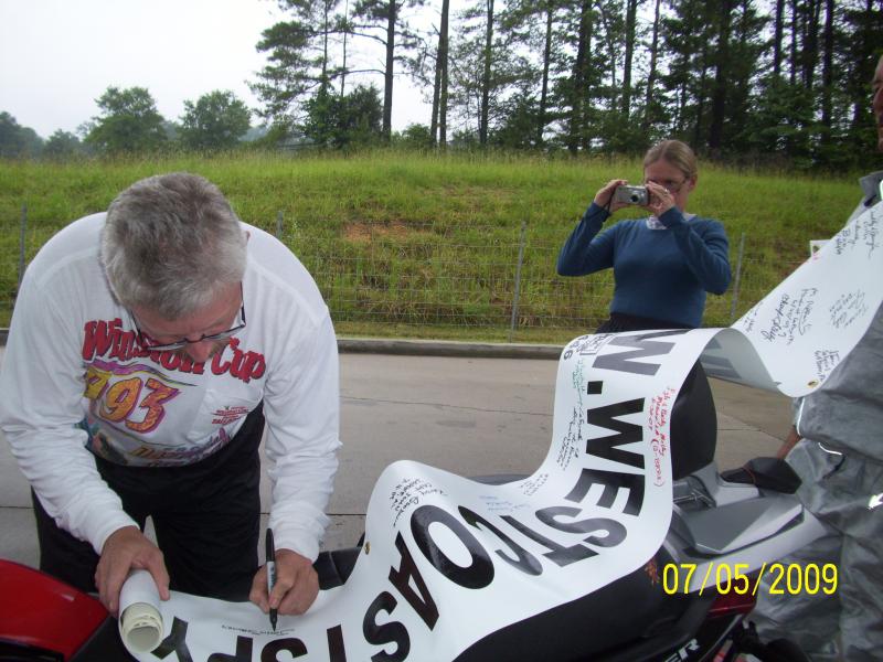 John signing the banner and Sherry taking his picture.