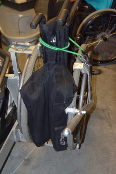 The only thing the bungy does is compress the back of the folded chair to give better visibility to the Spyder driver. It has nothing to do with holdi