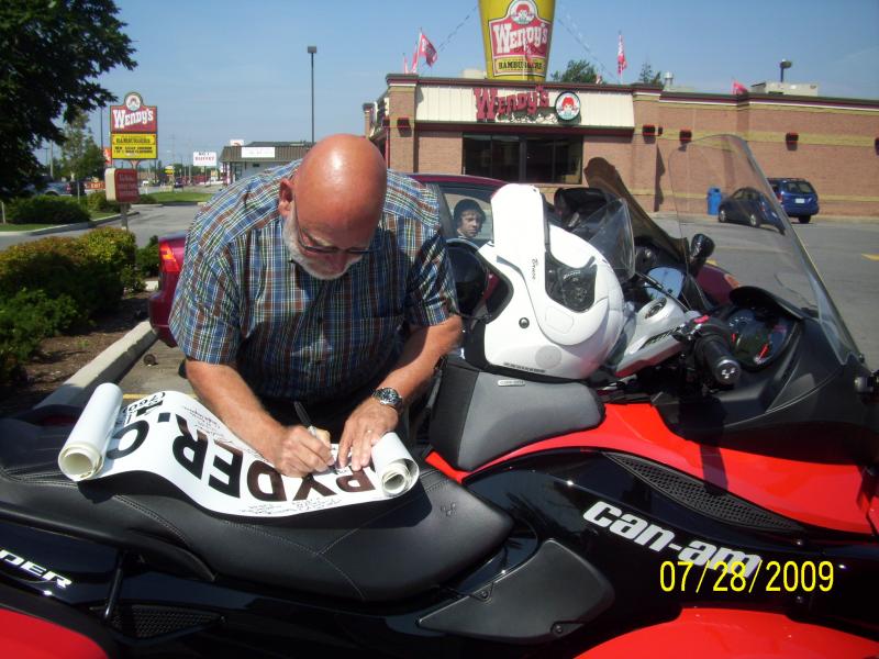 Tom signing the banner by accident. Some lookers knew someone who had a spyder so they went off to get him. When he arrived he mentioned his spyder wa