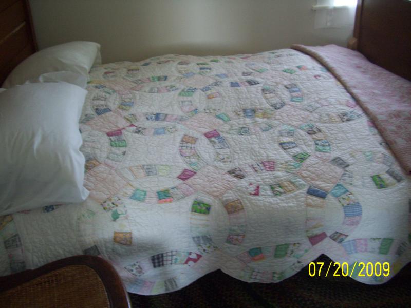 Wedding ring quilt on this old bed. Most had feather ticking pillows and mattresses. Also underlying mattress of straw. Some of the beds had the rope 