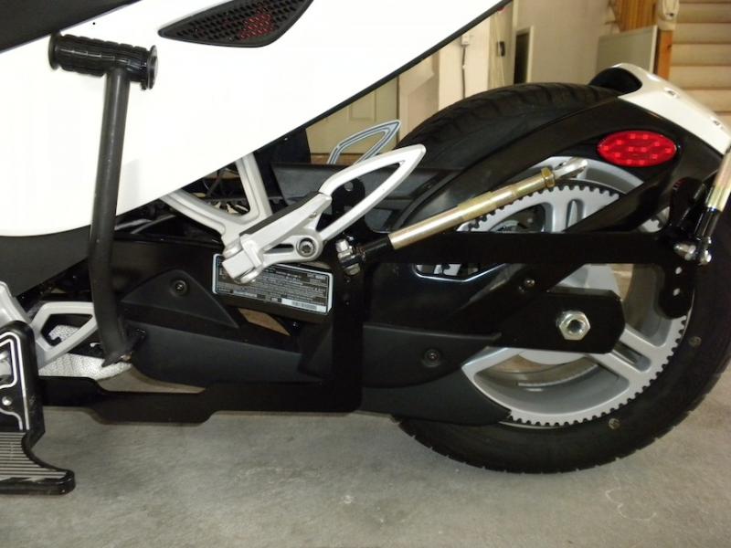 Wheelchair bracket with folding arms, held on by two bolts. One bolt through existing rear foot peg and second through hole drilled into ISCI floorboa