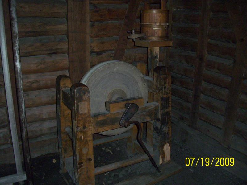 Whetstone or grinding stone. Small barrel of water atop to help cool off while grinding so you don't break the blade.